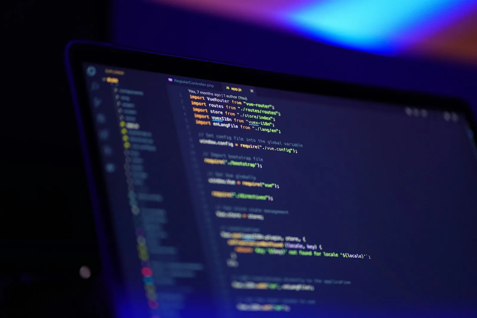Notebook mit geöffnetem Programmcode in einem abgedunkelten Raum.